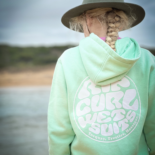 Woman in a mint hoodie on the beach