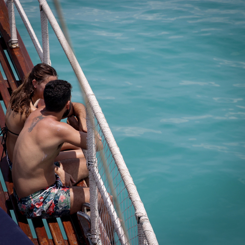 Friends relaxing on a boat over turquoise water