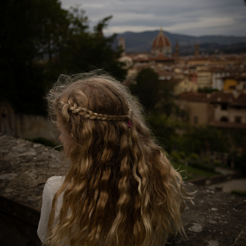 Woman with braided hair overlooking a hillside town