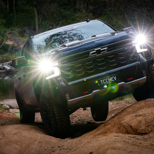 4WD truck with headlights on at dusk