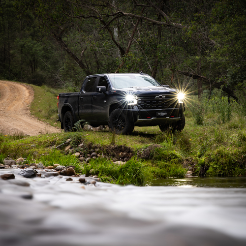 4WD truck fording a forest stream